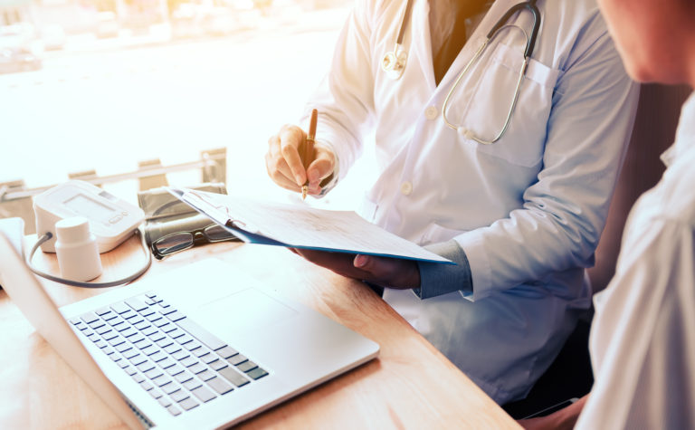 asian,male,doctor,hand,holding,pen,writing,patient,history,list